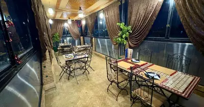 a room with two tables and chairs in a restaurant at Riad Le Petit Patrimoine De Fés in Fès