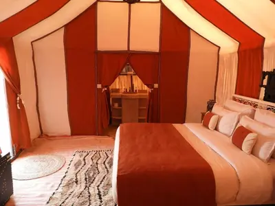 a bedroom with a large bed in a room at Sleeping in a Luxury tent in Merzouga desert in Merdani