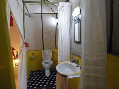 a small bathroom with a toilet and a sink at Sleeping in a Luxury tent in Merzouga desert in Merdani