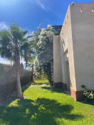 a palm tree in a yard next to a building at La Rose des Sables in Marrakech