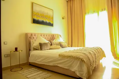 a bedroom with a bed with a large window at La Rose des Sables in Marrakech