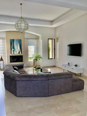 a large living room with a couch and a tv at La Rose des Sables in Marrakech