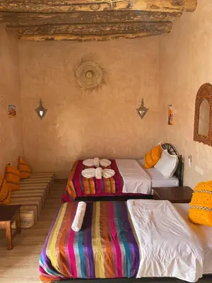 a room with two beds with bows on them at Riad Dades Birds in Boumalne