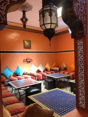 a living room with couches and tables in a room at Dar fatima merzouga in Merzouga
