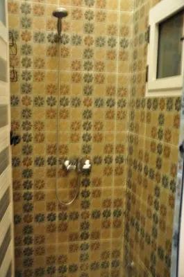 a shower with a glass door in a bathroom at Dar fatima merzouga in Merzouga