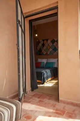 a bedroom with a bed through a doorway at Kasbah Flilou in Aït Ougliff