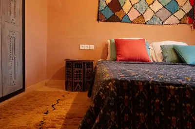 a bedroom with two beds with colorful pillows at Kasbah Flilou in Aït Ougliff