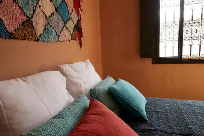 a room with a bed with pillows and a blanket at Kasbah Flilou in Aït Ougliff