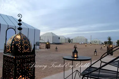 a view of a beach with white buildings and lights at Luxury Tented Erg Chebbi in Merzouga