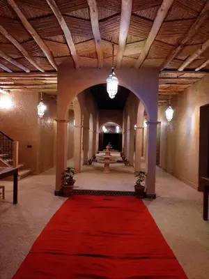 a large hallway with a red carpet in a building at Riad Caravasar in Merzouga