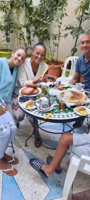 a group of people sitting around a table eating food at Gite El Menzeh in Moulay Idriss Zerhoun
