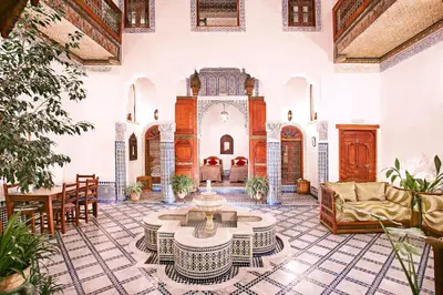 a large living room with a table and chairs at Dar Drissi in Fès