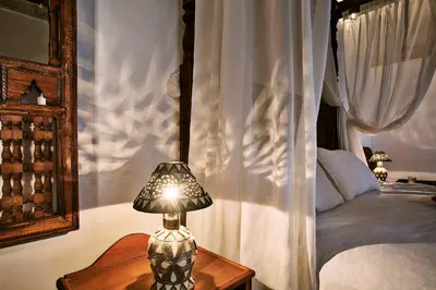 a lamp sitting on a table next to a bed at Dar Drissi in Fès