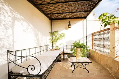 a balcony with a bed and a table at Dar Drissi in Fès