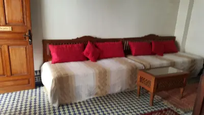 a bedroom with two beds with red pillows at Dar Drissi in Fès