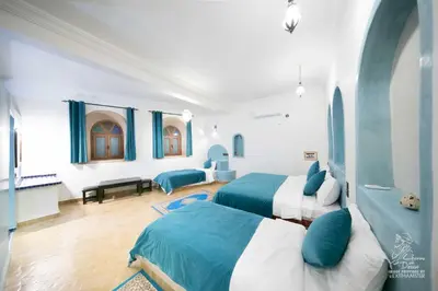 two beds in a room with blue and white at L'homme Du Désert A Merzouga in Merzouga
