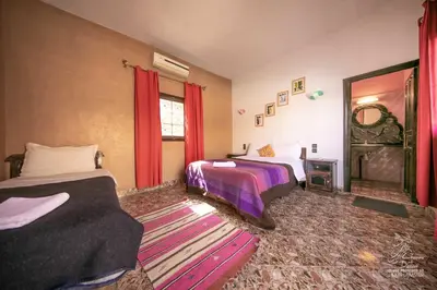 a bedroom with two beds and a mirror at L'homme Du Désert A Merzouga in Merzouga