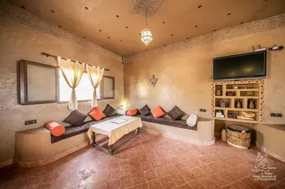 a living room with a couch and a tv at L'homme Du Désert A Merzouga in Merzouga