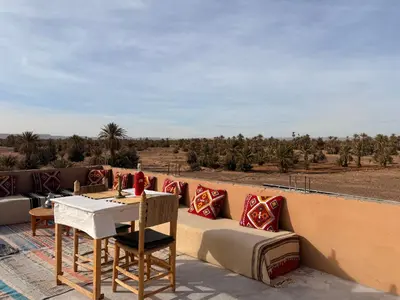 a patio with a couch and a table with a view at Dar Talmoudi ,Traditional Riad, Local Food, Camel , Desert Excursions in Tagounite