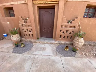 a door of a house with potted plants in front of it at Dar Talmoudi ,Traditional Riad, Local Food, Camel , Desert Excursions in Tagounite