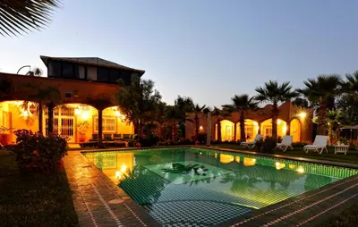 a swimming pool in front of a house at Villa du Cedre in Marrakech
