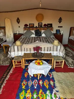 a bedroom with a bed with a table with fruit on it at Camp Desert Bivouac Chegaga in El Gouera