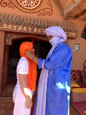 two women in turbans standing in front of a store at Camp Desert Bivouac Chegaga in El Gouera
