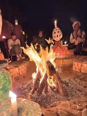 a group of people sitting around a campfire at Desert Bivouac Mhamid in Mhamid