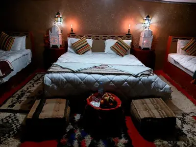 a bedroom with a large bed and benches in it at Desert Bivouac Mhamid in Mhamid