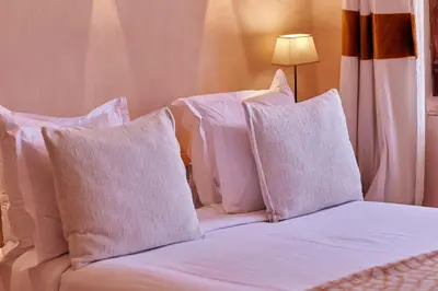 a bed with white pillows on top of it at Riad Caravane in Aït Ben Haddou