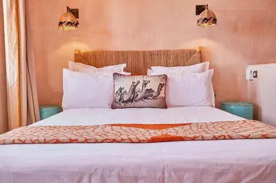 a bedroom with a bed with white sheets and pillows at Riad Caravane in Aït Ben Haddou