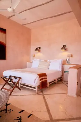 a bedroom with a large white bed in a room at Riad Caravane in Aït Ben Haddou