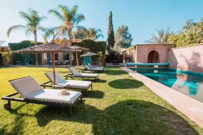 a yard with lounge chairs and a swimming pool at Villa Magtafa in Marrakech
