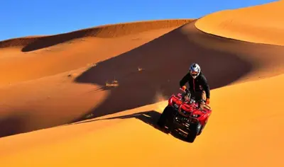 a person riding a quad bike in the desert at Sultan Luxury Camp in Merzouga