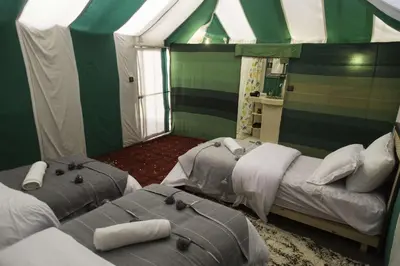 two beds in a room with a tent at Sultan Luxury Camp in Merzouga