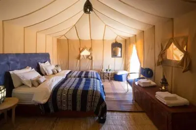 a bedroom with a bed in a tent at Sultan Luxury Camp in Merzouga
