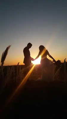 a man and a woman sitting in front of the sunset at Sultan Luxury Camp in Merzouga