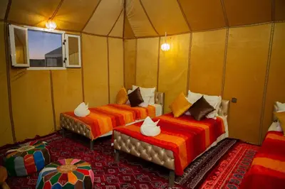a room with two beds in a tent at Luxury Desert Queen Camp in Merzouga