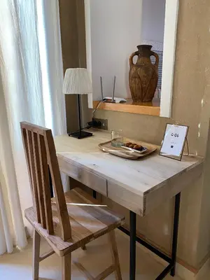a wooden table with a chair and a vase on it at Kasbah Tamsna in Ouarzazate