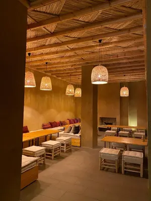 a restaurant with tables and chairs and chandeliers at Kasbah Tamsna in Ouarzazate