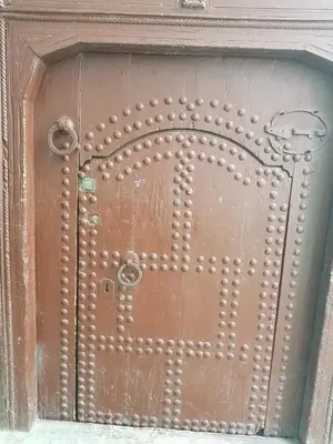 an old wooden door with beads on it at Dar Ines in Moulay Idriss Zerhoun