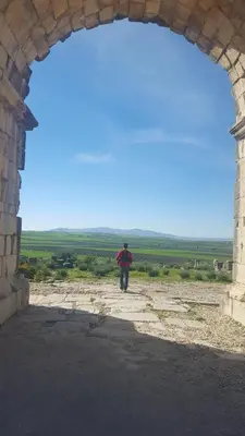 a man walking through a stone archway at Dar Ines in Moulay Idriss Zerhoun