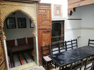 a room with a table and a door and a table and chairs at Dar Ines in Moulay Idriss Zerhoun
