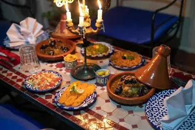 a table topped with plates of food and candles at DAR EL AAMOURI in Fès