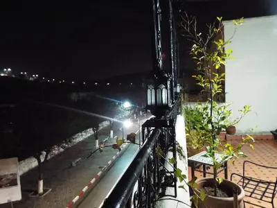 a balcony with a view of the ocean at night at DAR EL AAMOURI in Fès