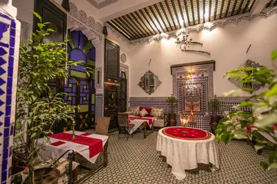 a room with a table and chairs and plants at DAR EL AAMOURI in Fès