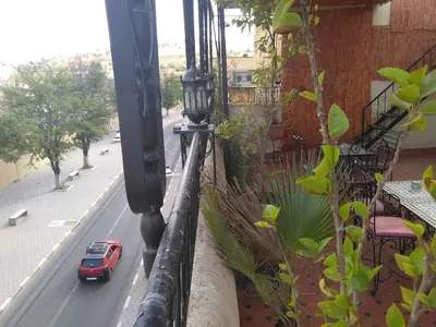 a red car driving down a street on a balcony at DAR EL AAMOURI in Fès