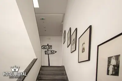 a hallway with pictures on the walls and stairs at Hôtel Royal Urban Concept in Fès