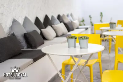 a row of tables and chairs with pillows on a couch at Hôtel Royal Urban Concept in Fès
