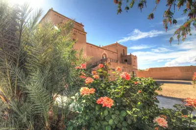a building with a bunch of flowers in front of it at kasbah 123 soleil in Skoura